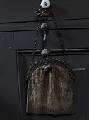 Vintage Damen Abendtasche auf Möbelgriff einer Schublade gehängt