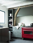 Kitchen with red, retro gas cooker and grey-painted cabinets in rustic interior