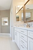 Grosszügiges Badezimmer mit weißem Waschtisch, Mosaikfliesen & Spiegel