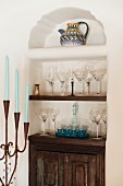 Holzschränkchen & Regalböden mit dekorativen Gläsern in Wandnische