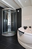 Modern shower cabinet and whirlpool bathtub in black and white bathroom in Scandinavian wooden house