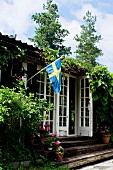 Rustic wooden house with Swedish flag and lattice doors