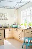 Bright, country-house-style kitchen with L-shaped counter below window