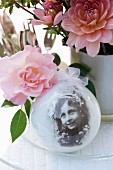 Nostalgic arrangement of snow globe and roses on table