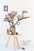 Branches of magnolia in stoneware pot on Tablo side table