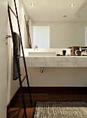 Handtuch-Leiter aus Bambus vor Marmor-Waschtisch mit Spiegelfront