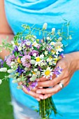 Woman holding posy of wild flowers