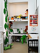 Fitted shelves of cushions and toys in niche next to floor-length, leaf-patterned curtains in child's bedroom
