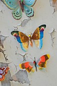 Colourful butterfly ornaments on wooden board with peeling paint