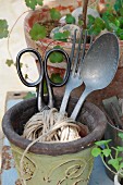 Old scissors, aluminium cutlery and packing string in vintage planter