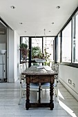 Rustikaler Vintage Holztisch und Stühle weiss lackiert auf weiss lasiertem Dielenboden in Loggia ähnlichem Raum