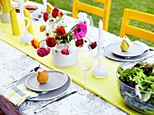 Colourful vase of ranunculus on festively set garden table