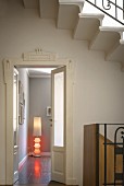 White Art Deco door frame; modern standard lamp with red light elements in corner