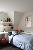 Single bed against white, fitted desk and soft toys on shelves