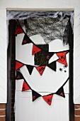 Bunting and spiders' webs on front door as Halloween decorations