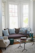 Window seat in bay window with seat cushions and many scatter cushions