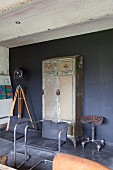 Retro Freischwinger vor Vintage Metallschrank an dunkelgrau getönter Wand