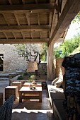 Seating area against stone wall on roofed terrace