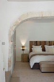 Double bed in bedroom with stone arch