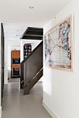Staircase with solid, metal balustrade in narrow hallway