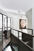 Landing with metal staircase balustrade and glass and metal partition with door