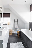Designer, attic bathroom with large, grey floor tiles