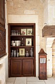 Dark wooden dresser fitted in niche in Mediterranean interior