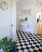 Open-plan hallway with chequered floor and white chair and console table against wall