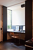 Home office in niche with folding sliding doors and light falling through window to one side; classic chair by Mart Stam