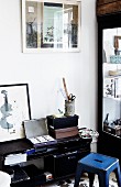 Schwarzes, hablhohes Regal mit Aufbewahrungsboxen und Zeichenutensilien, blauer Metall Hocker im Retro Stil