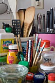 Colourful mixture of kitchen utensils, chopsticks, wooden spoons and pots of spices