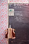 Beschriftete Türtafel mit Notizen in Küche mit geblümter Wand