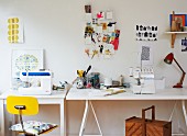 Improvisierter Arbeitstisch auf Böcken, an Wand Moodboard mit Büroutensilien