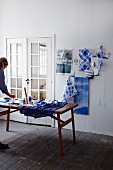 Indigo-blue batik fabric on wall and woman working