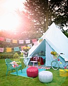 Party atmosphere in garden: seating area with colourful seats in front of tent decorated with bunting
