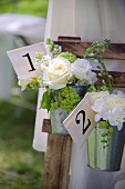 Bouquets of white roses in zinc buckets with numbered labels