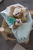 Bars of soaps on cords with beads, loofah glove and towel on rush-bottom stool