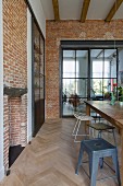 Brick wall in dining room; glass and steel sliding element in doorway leading to living room