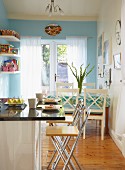 Küche mit Frühstückstresen und Essplatz vor hellblau getönter Wand