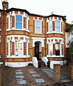 English terraced house with white elements in brick facade