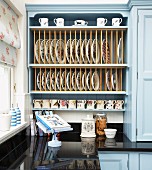 Pale blue country-house kitchen cabinet with integrated plate rack
