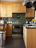 Einbauküche mit Eichenfronten im Landhausstil und dunkelgrünen Wandfliesen