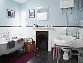 Bathroom with tiled dado, open fireplace and retro bathtub