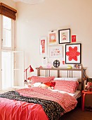 Double bed with red bed linen and pretty ornaments