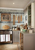 Rustic kitchen - counter with grey-painted base units and modern, stainless steel gas cooker