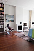 Seating area with modern fireplace, Eames chair and floor-to-ceiling bookcase