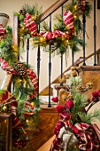 Weihnachtlich dekoriertes Treppengeländer mit Kiefernzweigen, Bändern und Lichterkette