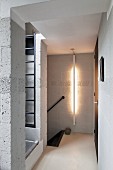 Breeze block walls; hallway with vertical strip light mounted on wall