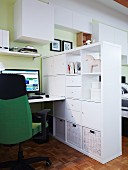 Reichlich Platz in weißem, schlichten Raumteilerelement zwischen Bett und Home Office