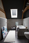 Heller Teppichläufer auf grauem Fliesenboden, Wände halbhoch gefliest in modernem Dachgeschoss Bad